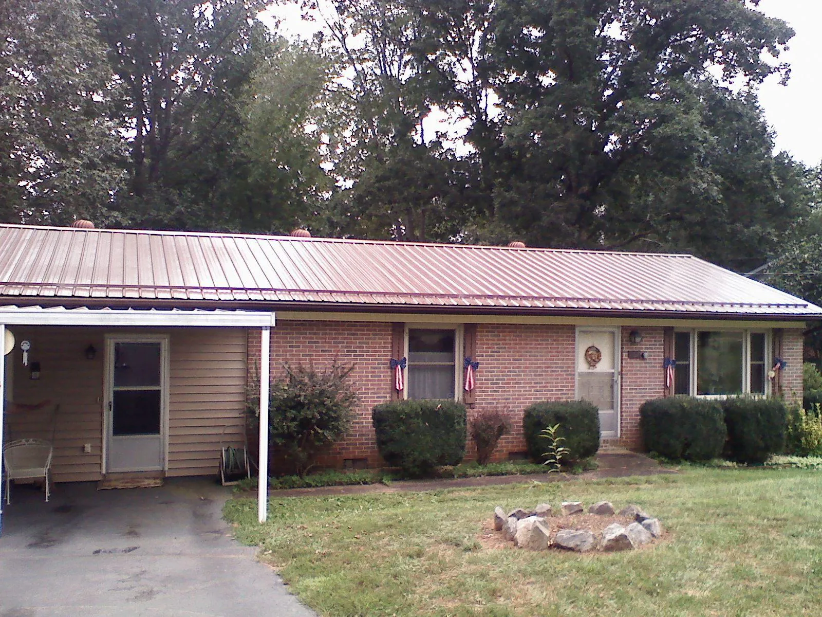 Bronze metal roof and carport on a brick ranch home — Roof Repair work by our crew in Medusa