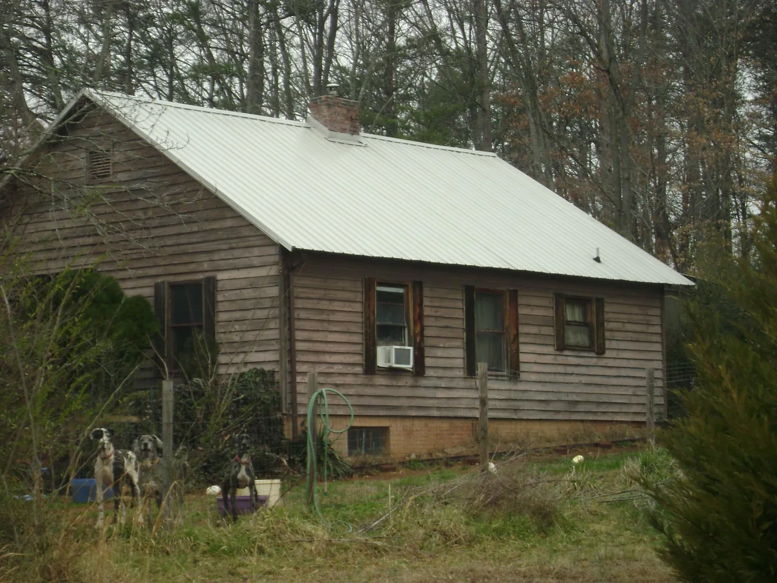 White metal roof on an old wood sided farmhouse, from a Metal Roof Installation job in Medusa